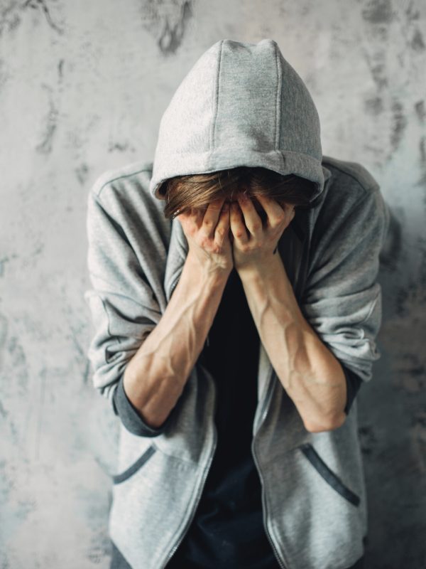 Depressed druggy sitting on the floor, withdrawal symptom. Narcotic addiction concept, drug addicted people